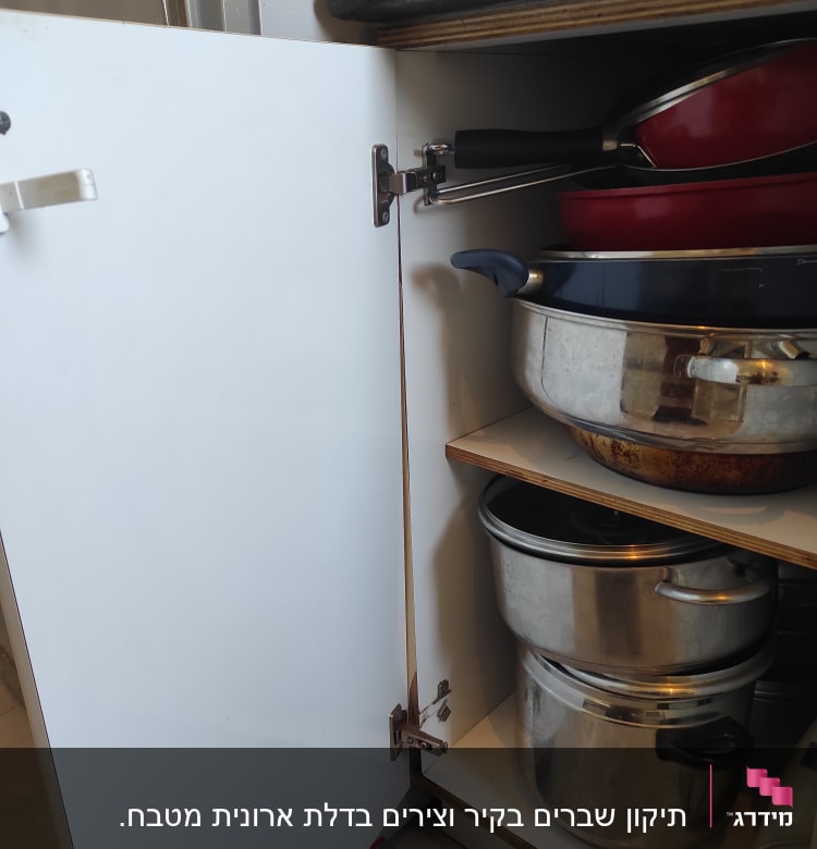ארון מטבח פתוח עם סירים ומחבתות